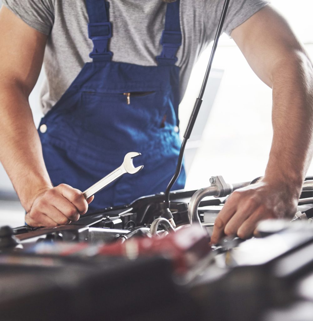 Picture showing muscular car service worker repairing vehicle Picture showing muscular car service worker repairing vehicle.